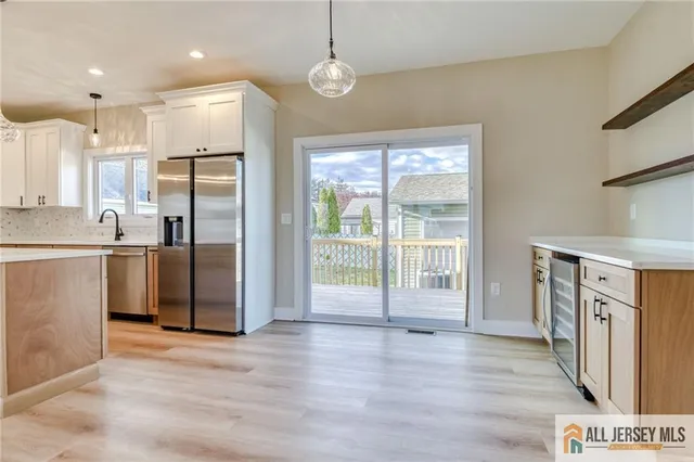 a view of a kitchen with a sink refrigerator and wooden floor