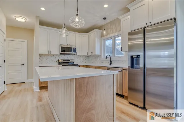 a kitchen with kitchen island a counter top space stainless steel appliances and cabinets