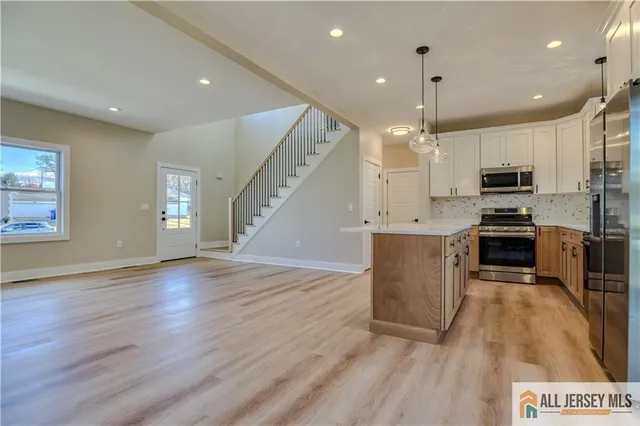 a kitchen with stainless steel appliances a refrigerator a stove top oven and sink