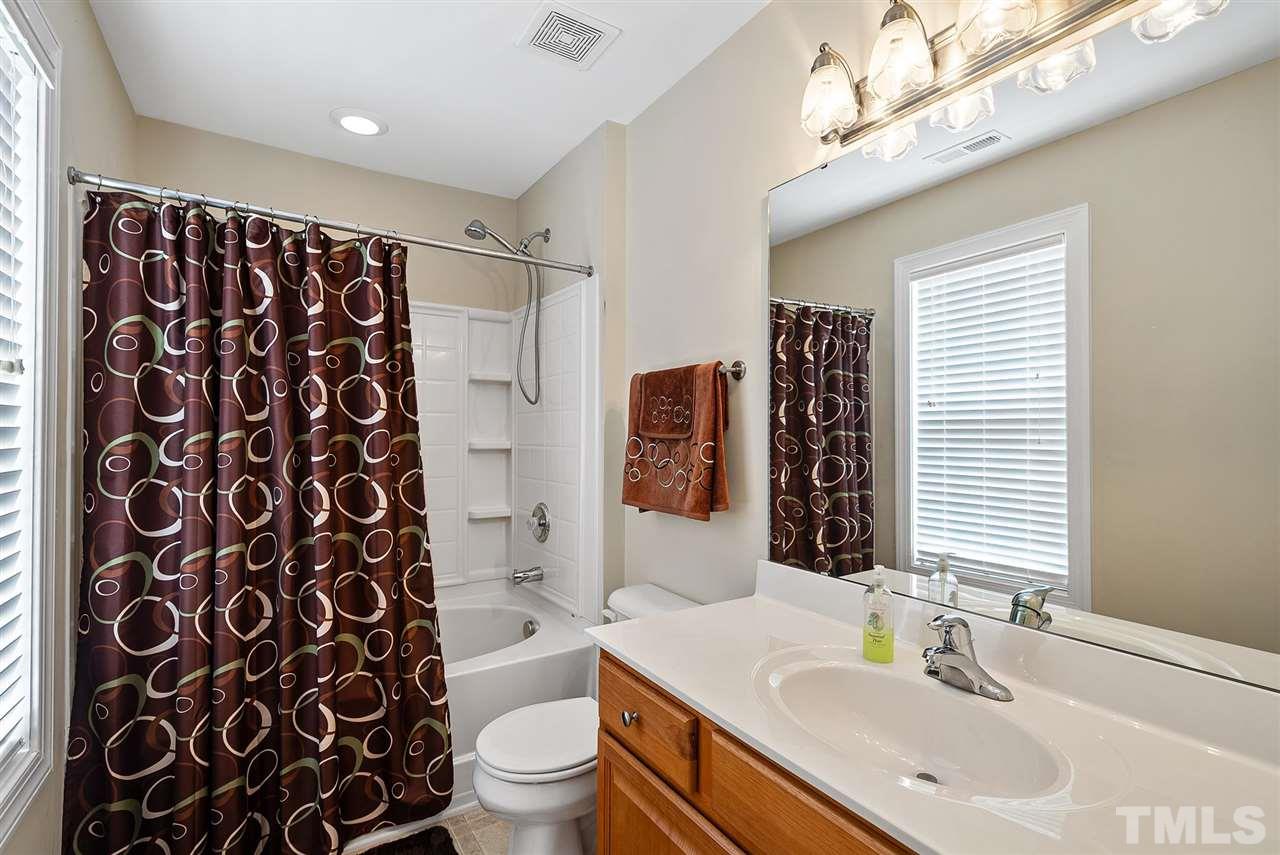 2632 Andover Glen Road Raleigh, NC 27604 - Photo 18 of 23 a bathroom with a sink toilet a mirror a vanity and shower