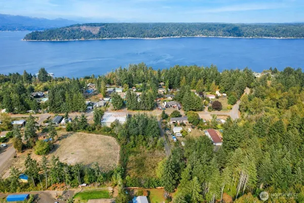 an aerial view of a residential houses with outdoor space and lake view