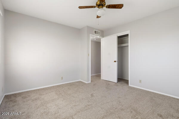 6117 East Decatur Street Mesa, AZ 85205 - Photo 17 of 29 an empty room with a ceiling fan and carpet