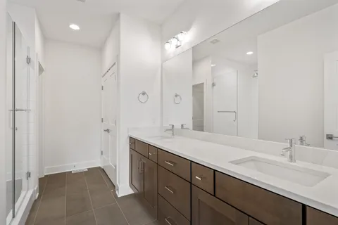 a spacious bathroom with a shower sink double and mirror