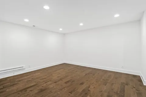 an empty room with wooden floor and white walls