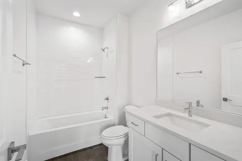 a bathroom with a sink toilet vanity and shower