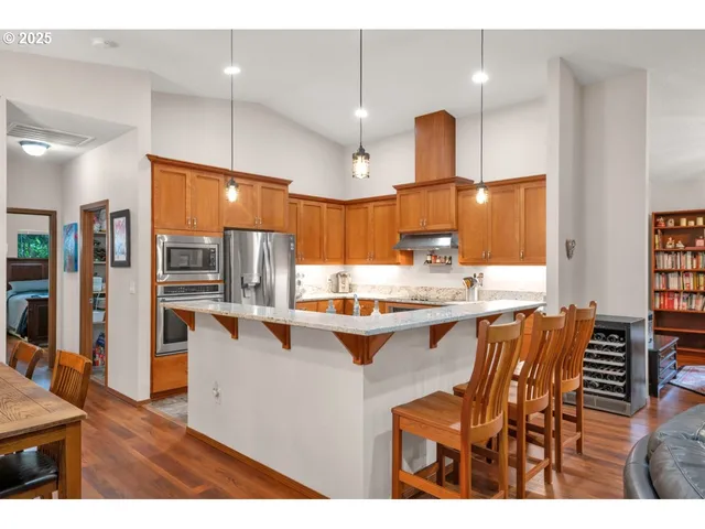 a kitchen with stainless steel appliances kitchen island granite countertop a table and chairs in it