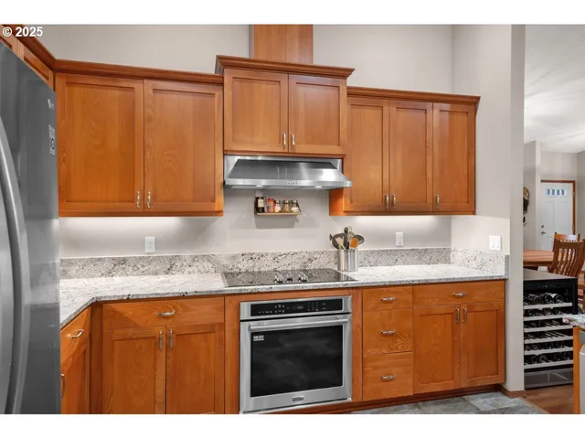 a kitchen with granite countertop a sink a stove and cabinets