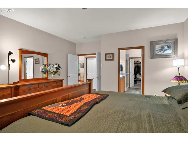 a living room with a bed furniture flat screen tv and a large window