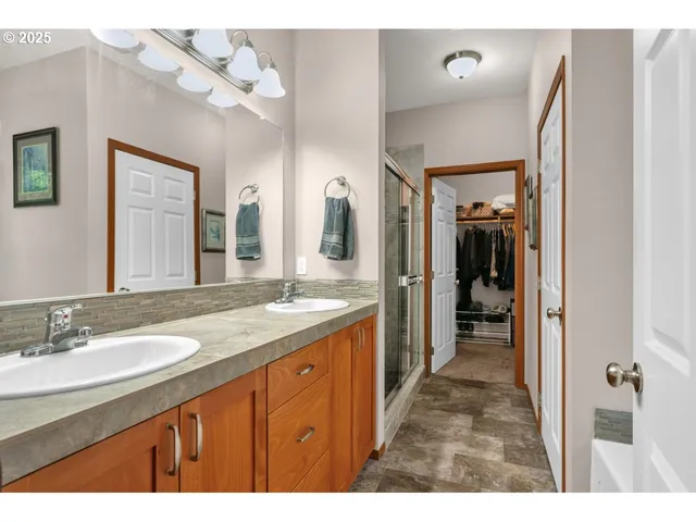 a bathroom with a granite countertop sink mirror and a shower