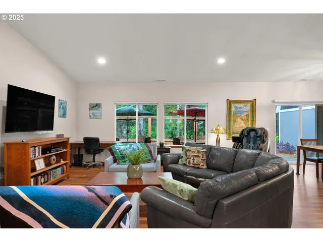 a living room with furniture a flat screen tv and a large window