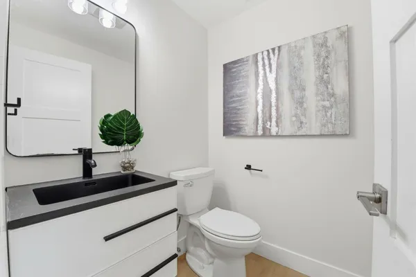 a bathroom with a toilet a sink and mirror