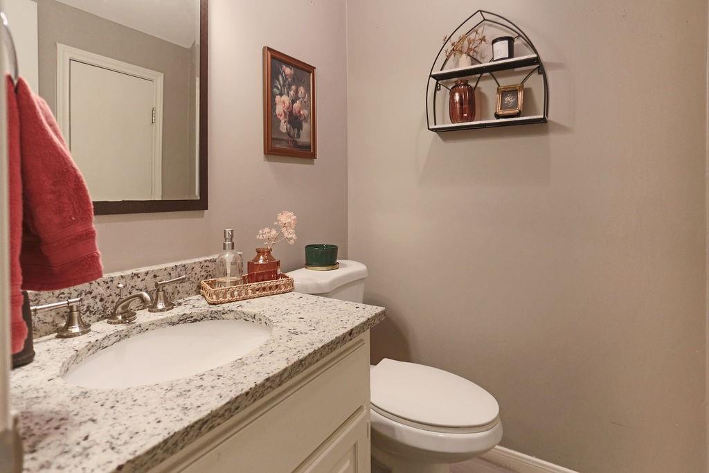 1307 Kinney Avenue, Unit 121 Austin, TX 78704 - Photo 10 of 12 a bathroom with a granite countertop toilet a sink and mirror
