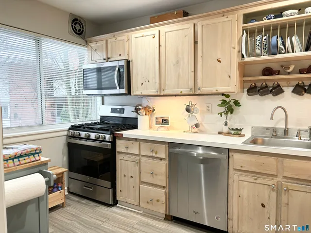 a kitchen with stainless steel appliances granite countertop a sink stove and cabinets