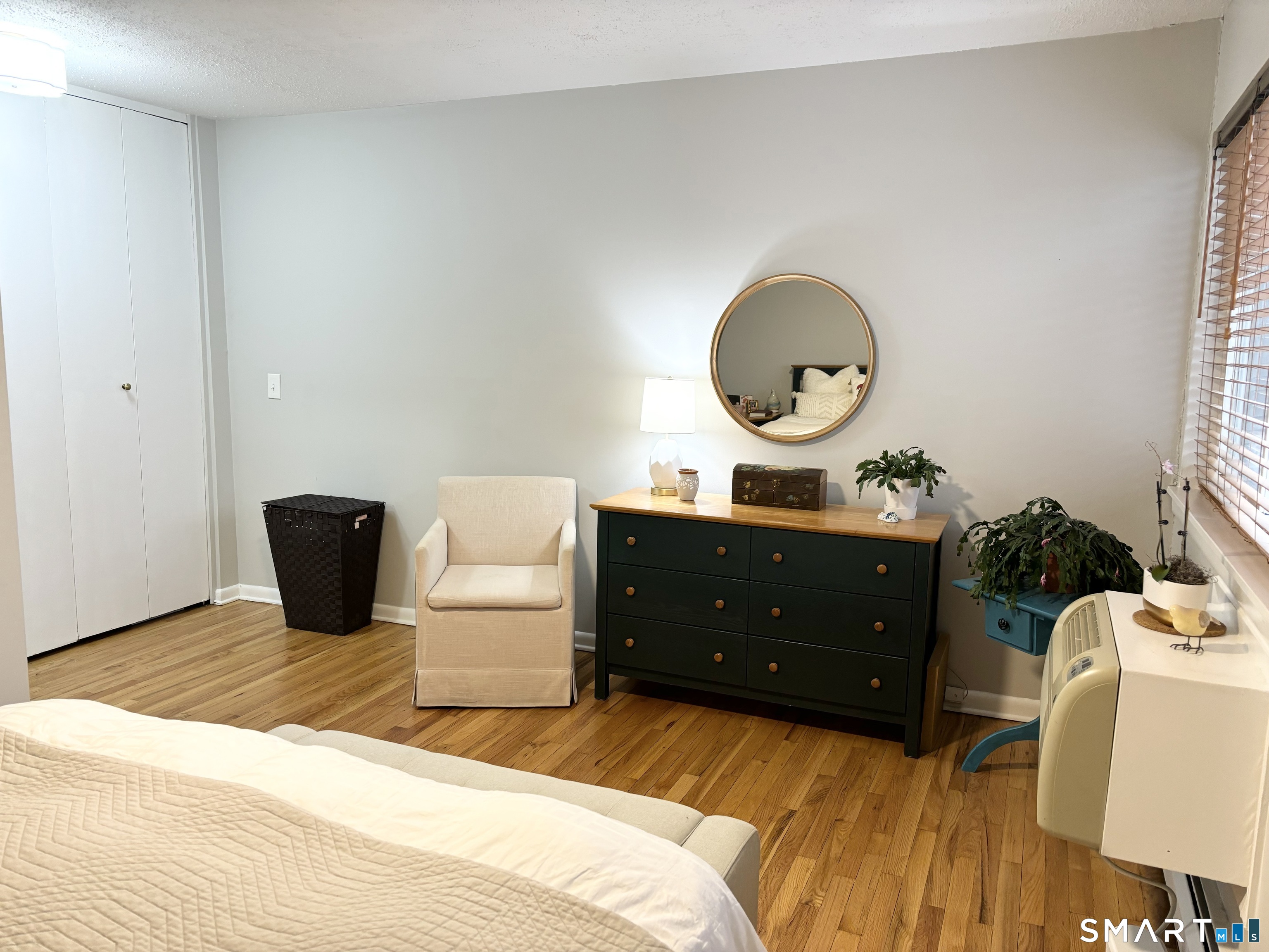 208 Flax Hill Road, Unit 12 Norwalk, CT 06854 - Photo 8 of 12 a bedroom with a bed and a potted plant