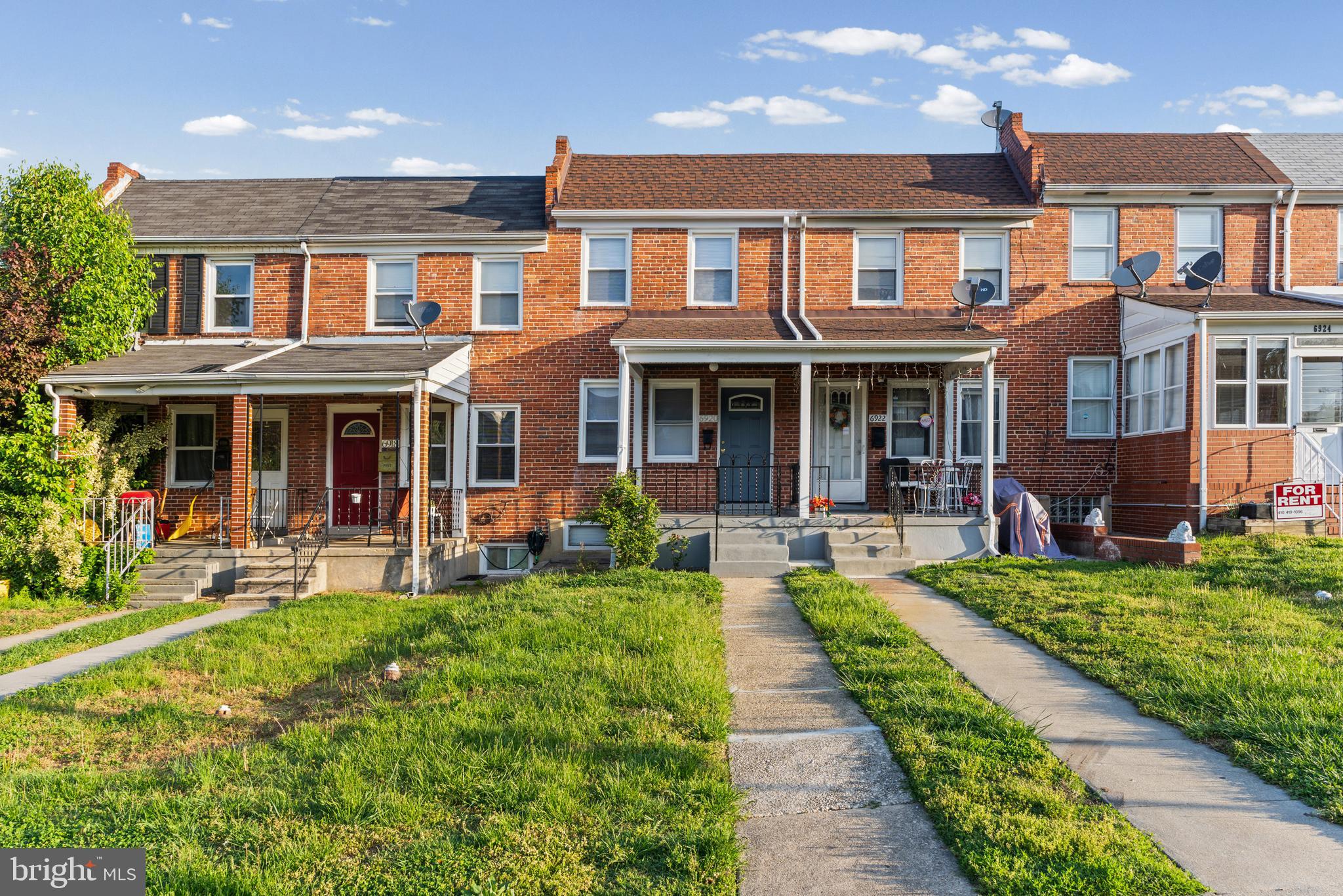front view of a brick house with a yard garden and patio