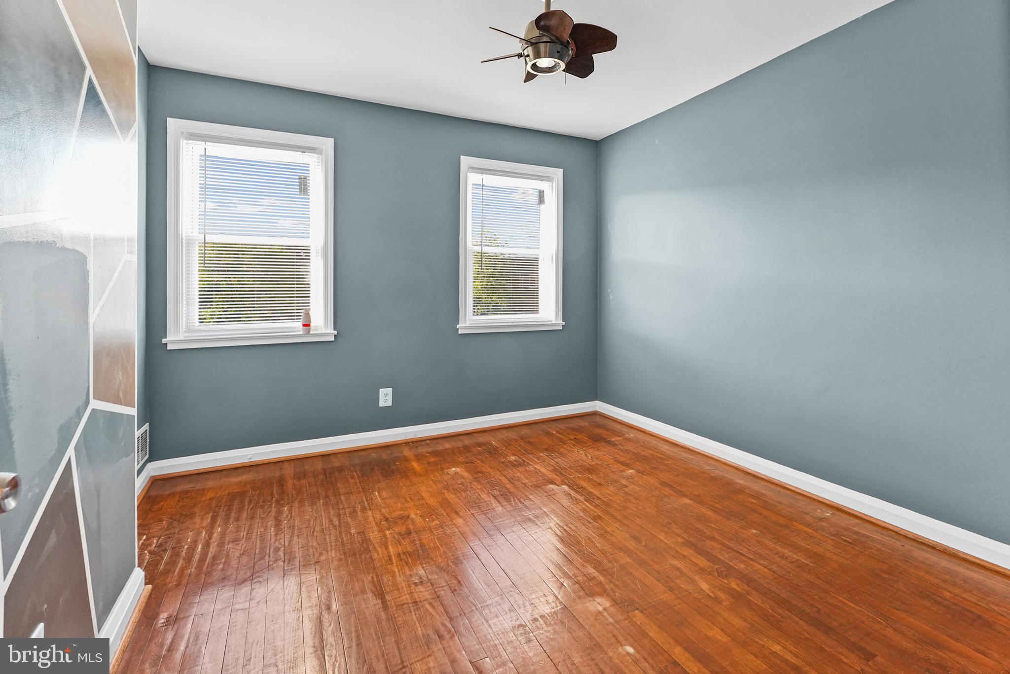 6920 Conley Street Baltimore, MD 21224 - Photo 11 of 12 a view of an empty room with a window and wooden floor