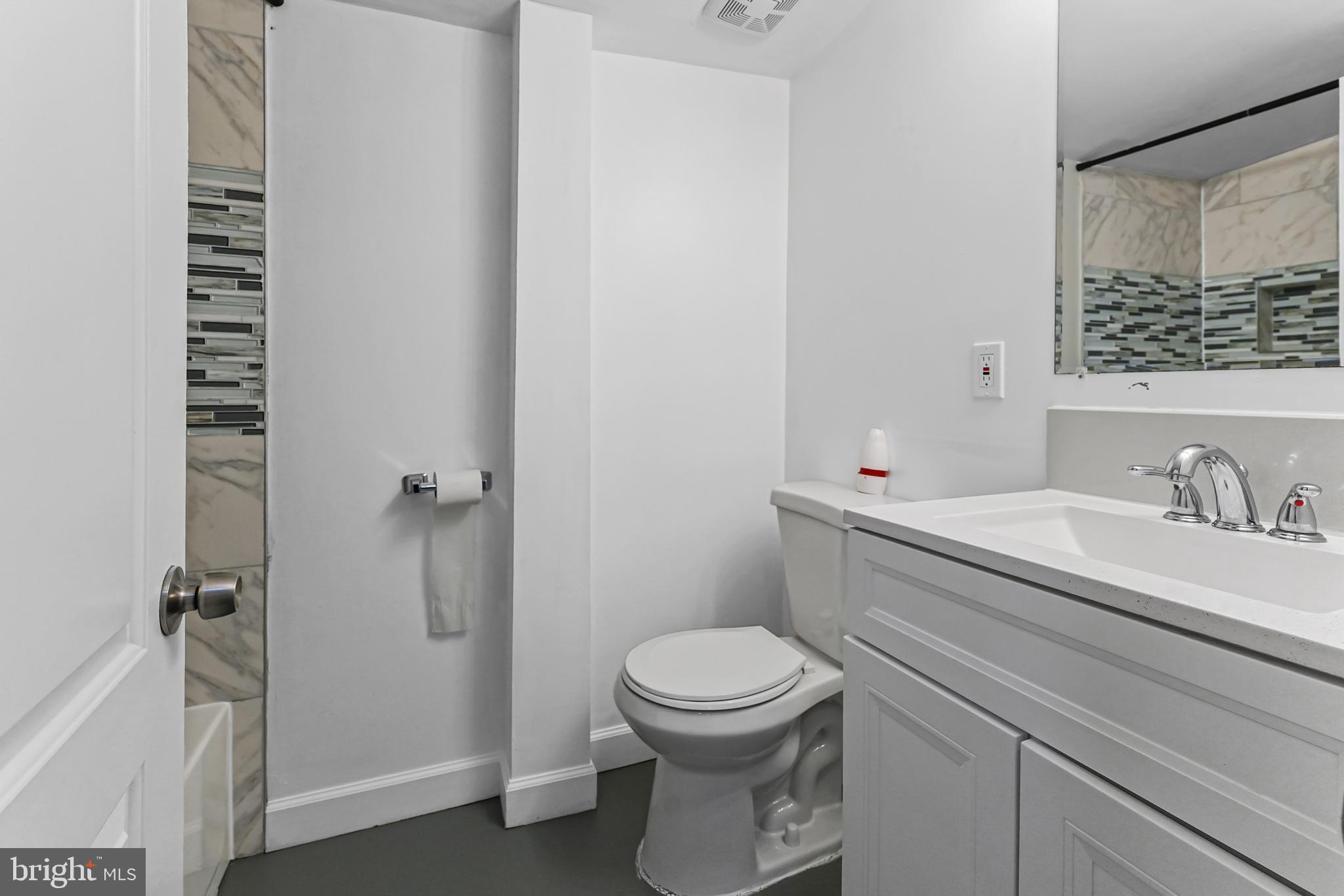 6920 Conley Street Baltimore, MD 21224 - Photo 7 of 12 a bathroom with a granite countertop sink toilet and shower