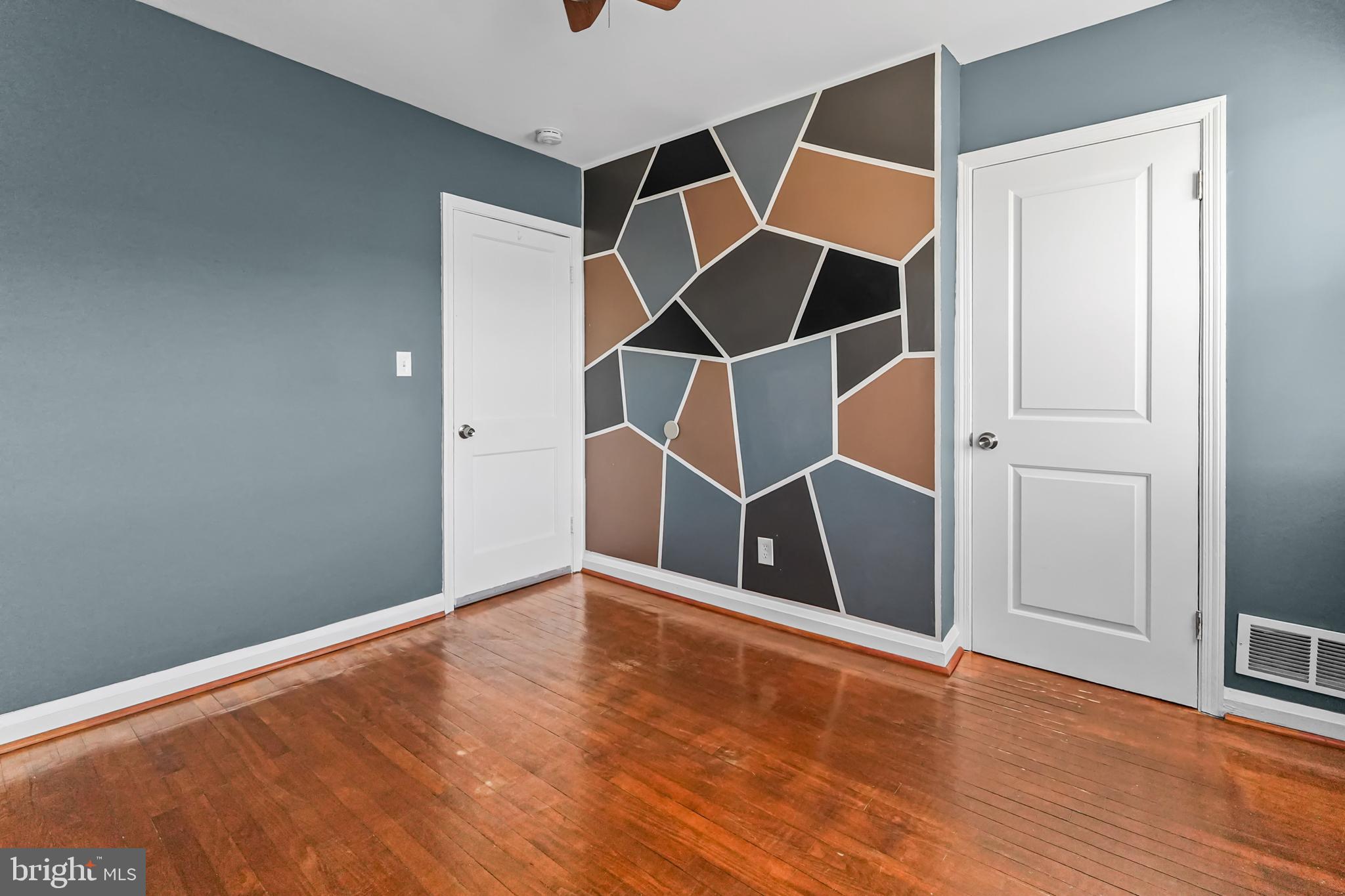 6920 Conley Street Baltimore, MD 21224 - Photo 10 of 12 an empty room with wooden floor and entryway