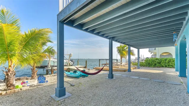 a living room with furniture a chandelier and a dining table with wooden floor