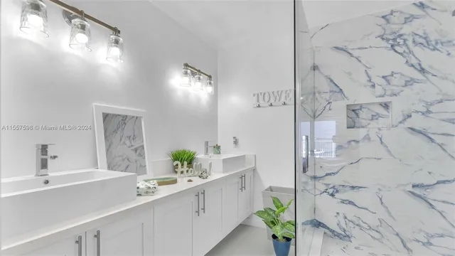 a kitchen with stainless steel appliances kitchen island a refrigerator sink and white cabinets