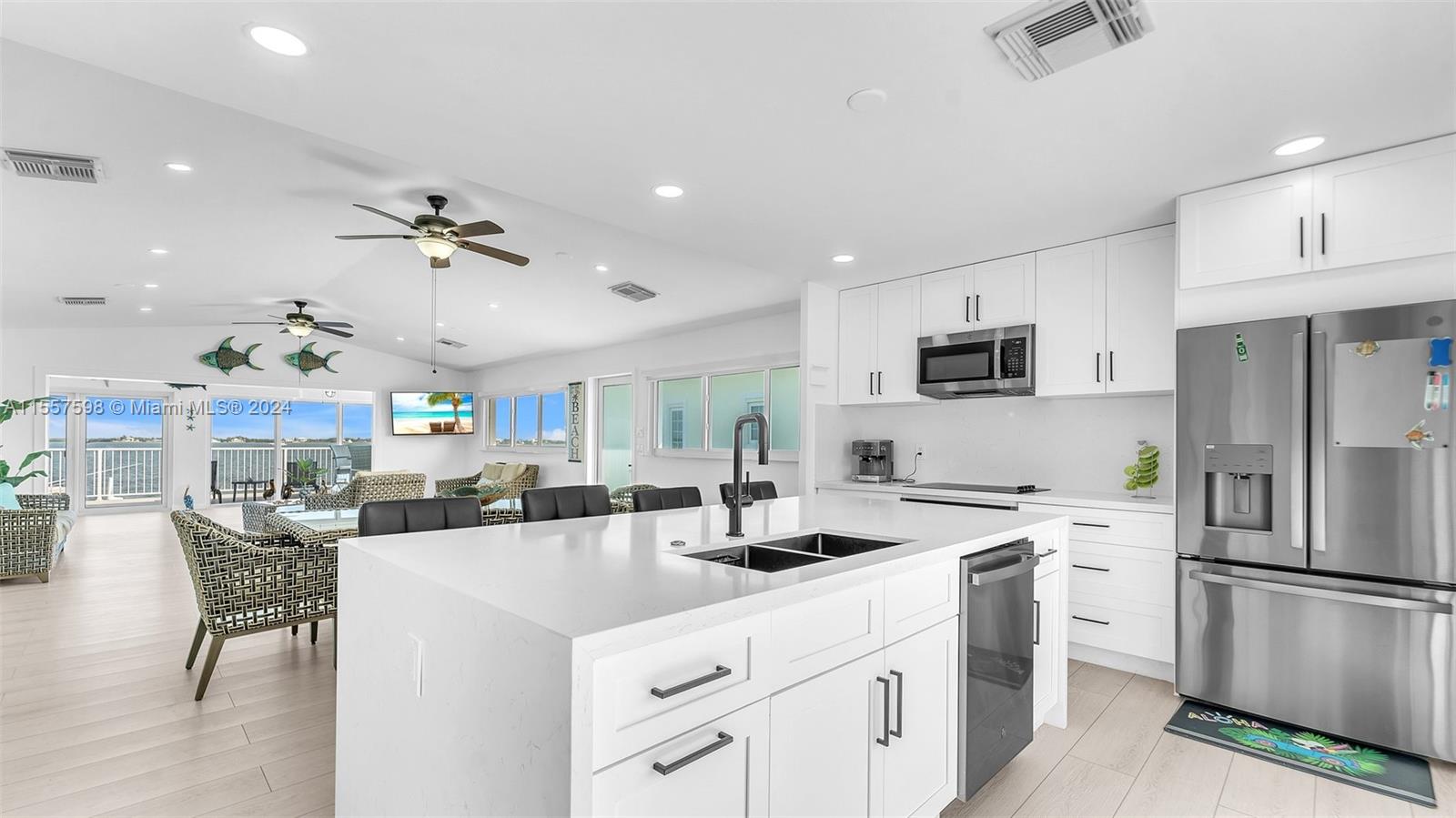 441 La Fitte Road Summerland Key, FL 33042 - Photo 55 of 81 a kitchen with stainless steel appliances kitchen island a refrigerator sink and white cabinets