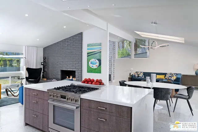 a kitchen with a stove a sink a dining table and chairs