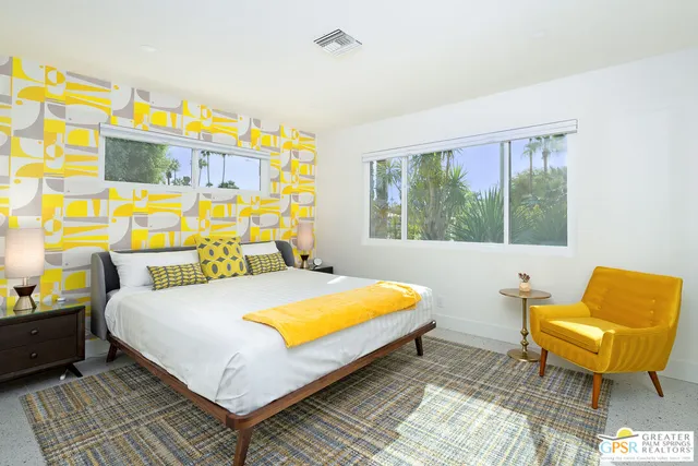 a bed sitting in a bedroom next to a window