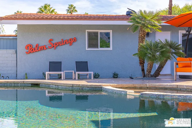 an outdoor sitting area with couch and umbrella