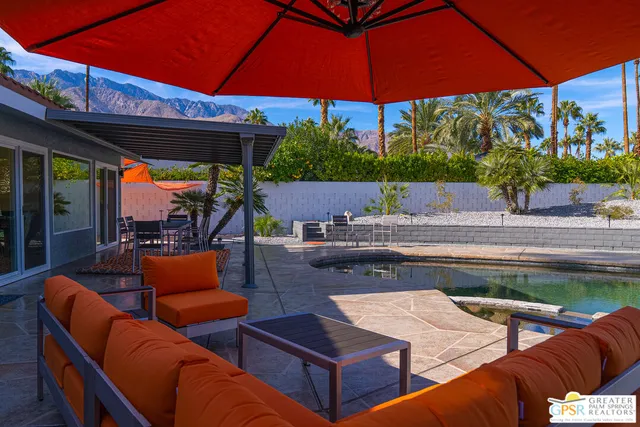 a view of a patio with table and chairs potted plants and palm tree