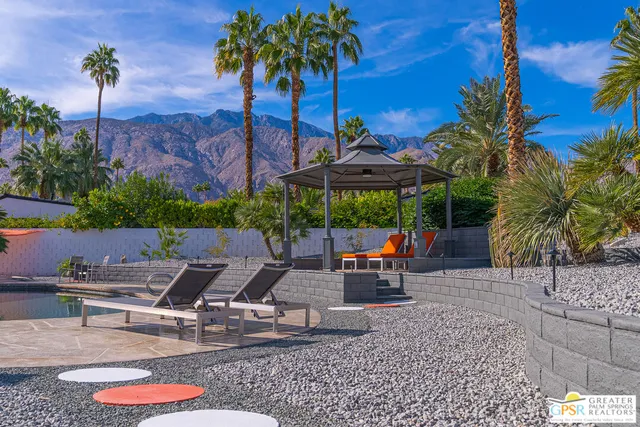 a view of swimming pool with a garden and plants