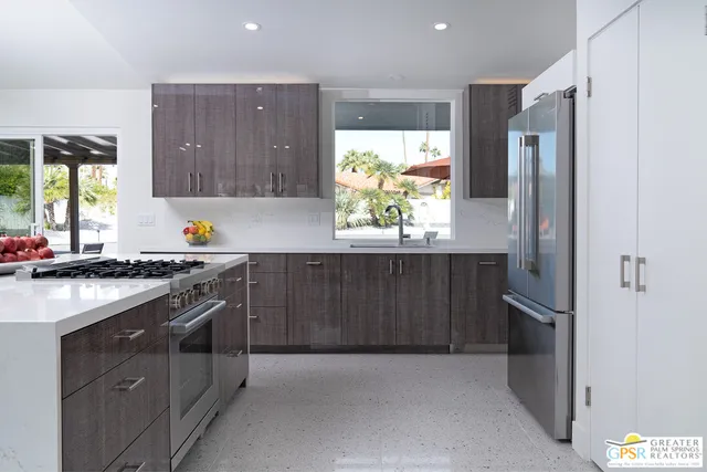 a kitchen with stainless steel appliances granite countertop a refrigerator and a sink