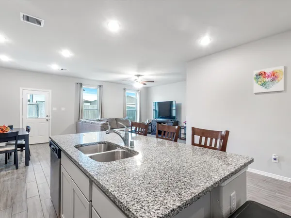 a kitchen with a sink a refrigerator and white cabinets