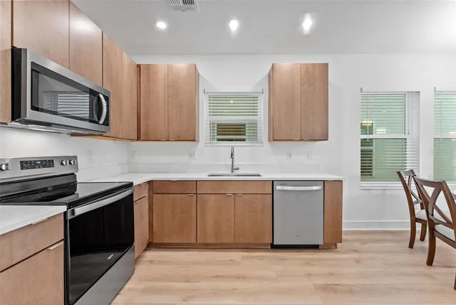 a kitchen with stainless steel appliances granite countertop a stove a sink and a microwave