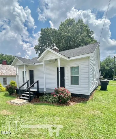 a view of a chair and table in backyard of the house