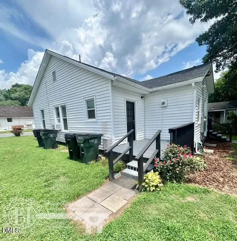 a backyard of a house with table and chairs