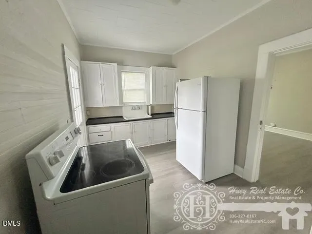 a kitchen with a refrigerator sink and cabinets