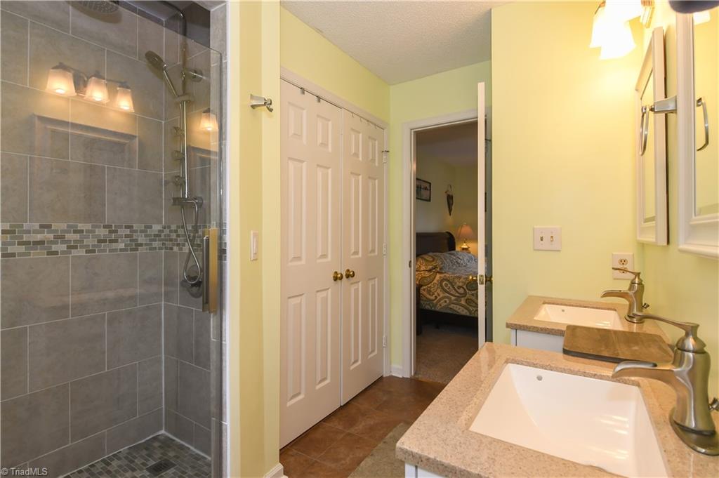 4105 Appleton Road Greensboro, NC 27405 - Photo 16 of 30 Stunning remodeled bath offers standup shower, double vanities, and nice linen closet.