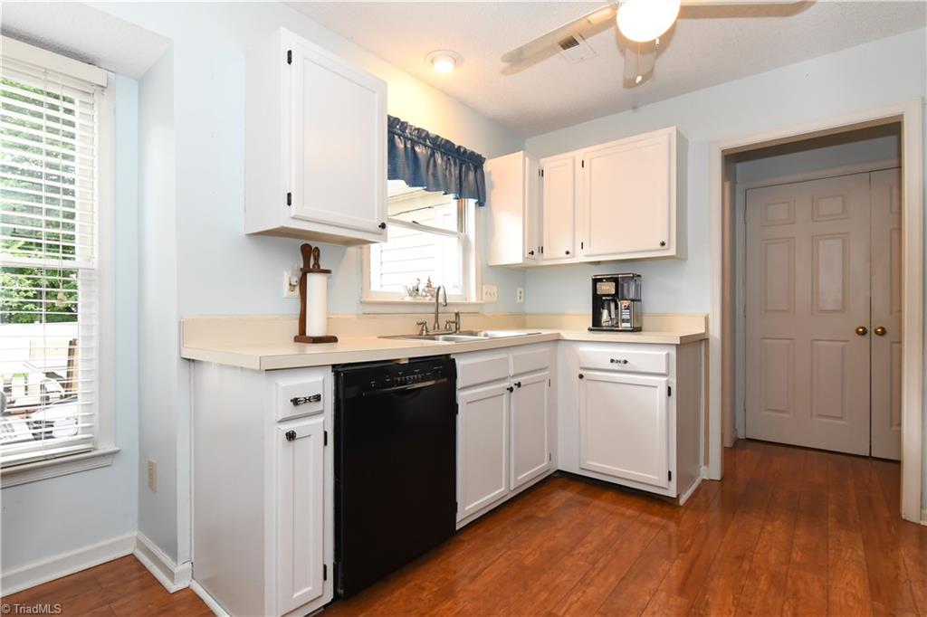4105 Appleton Road Greensboro, NC 27405 - Photo 7 of 30 Great kitchen with white cabinets, black appliances and beautiful flooring.
