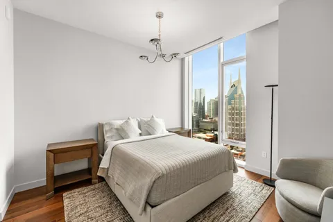 a bedroom with a bed couch and a window