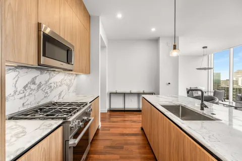 a kitchen with kitchen island granite countertop sink stove and cabinets