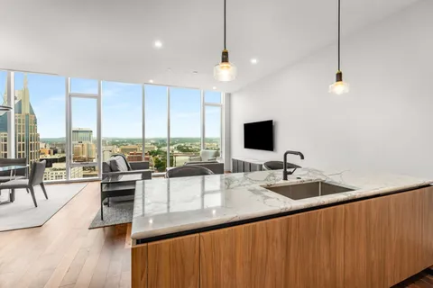 a very nice looking living room with a large window and wooden floor