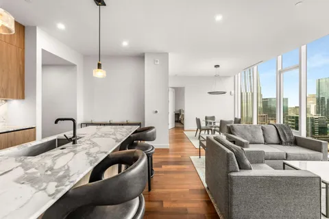 a living room with furniture wooden floor and a large window