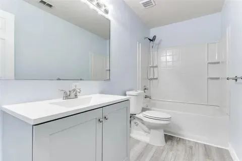 a bathroom with a sink toilet vanity and shower