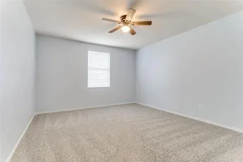 an empty room with windows and chandelier fan