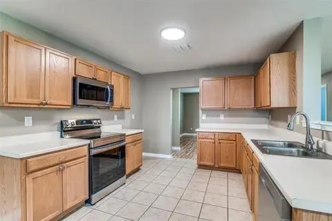 a kitchen with stainless steel appliances granite countertop a sink and dishwasher a stove top oven with wooden floor