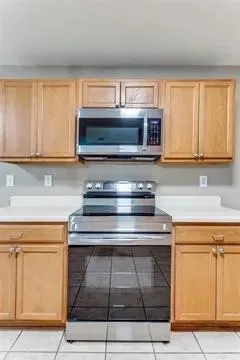 a kitchen with wooden cabinets and a stove top oven