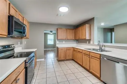 a kitchen with a sink stove top oven and cabinets