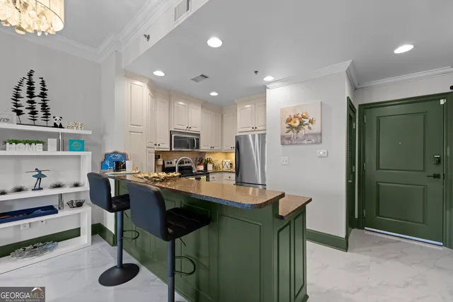 a dining hall with stainless steel appliances granite countertop a table and chairs in it