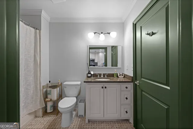 a bathroom with a granite countertop toilet sink and mirror