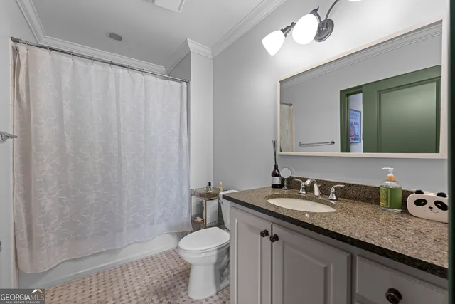 a bathroom with a granite countertop sink a toilet and a mirror
